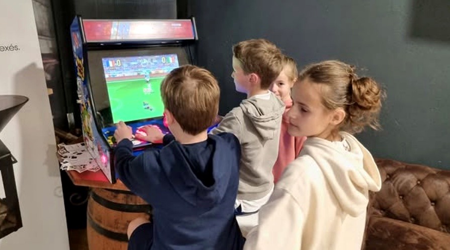Enfants jouant sur borne arcade